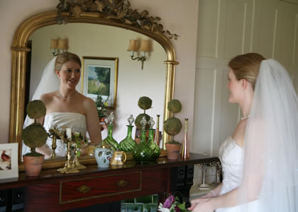 Wedding make-up and hair -  Surrey Bride at mirror on Wedding Day